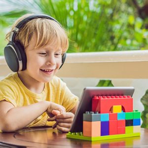 child wearing headphones using tablet